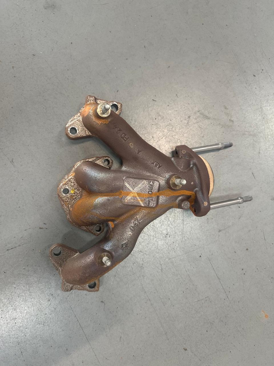 Exhaust manifold covered in surface rust before treatment